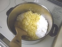鍋に生姜、砂糖、水を入れ、かき混ぜながら中火にかけます。<br />