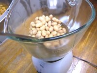 大豆は熱いうちに潰します。ジューサー、フードプロセッサーなどで何回かに分けて潰します。ポテトマッシャーで潰したり、ビニール袋に大豆を入れ麺棒で潰すこともできます。潰した大豆の固さは耳たぶくらいです(潰すときに煮汁で調整します)<br />
<br />