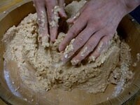 すりつぶした大豆は、人肌ほどの熱さに冷めています。塩きり麹と大豆を混ぜ合わせ、ソフトボールほどの味噌玉を作ります。<br />