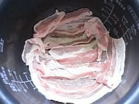鍋肌をサラダ油（分量外）をつけたペーパーで拭き、豚肉を敷き詰め、残った豚肉を細く切って具にする。