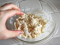 小麦粉、ベーキングパウダー、きび砂糖、サラダ油をボウルに入れ、分量の半量のお湯を加えてハンバーグをこねる要領で全体がポロポロになるまで指先で混ぜる。<br />
<br />