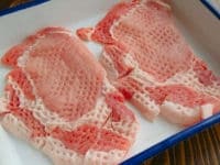 豚肉は筋の部分に数か所包丁を入れて筋切りをし、肉たたきなどで全体を軽く叩いて厚みをならします。軽く塩こしょうを両面にし、10分室温に置いて肉を常温にします。<br />