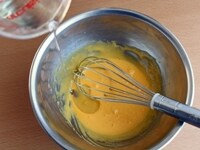 ボウルに卵黄を入れ、泡立て器で軽く解きほぐしたら、グラニュー糖を加え、やわらかなクリーム色になるまですり混ぜます。さらに、サラダオイル、牛乳を少しずつ順に加え、その都度、泡立て器でよく混ぜます。<br />