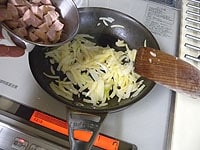 フライパンに、オリーブオイルとみじん切りのにんにくを入れ、弱火で炒めます。にんにくを取り出し、細切りに玉ねぎを炒め、豆と同じ大きさにきったソーセージを加え炒めます。<br />