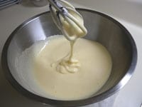 ボウルに卵を割りほぐし泡立てます。グラニュー糖を加えハンドミキサーで混ぜながら湯せん（ひとまわり大きいボウルに65度くらいの湯を張り、その上に卵を入れたボウルを置きます）にかけます。卵液が人肌に温まったら、湯せんからはずし、もったりとクリーム状になるまでしっかり泡立てます。<br />