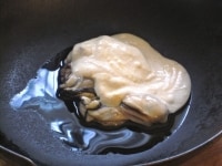 フライパンに油を入れて中火にかけ、フライパンが温まったら牡蠣とヨーグルト、カレー粉を加える。<br />