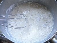 鍋に豆乳と片栗粉と塩を入れ、泡だて器で混ぜて溶かす。<br />