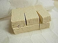 木綿豆腐はキッチンペーパーで包み、軽く重石を10分ほどかけて充分水気を切ります。次に豆腐を横半分を切り、縦に3等分してサイコロ状にします。片栗粉を全面にうすくまぶします。<br />
<br />