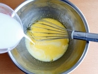 ボウルにときほぐした卵を入れ、グラニュー糖を加えて、泡立て器でよく混ぜます。半量の牛乳を加えてさらに混ぜます。<br />
