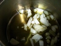 厚底の深鍋に、ざく切りにしたタマネギとオリーブオイルを入れ中火にかける。<br />