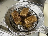 燻製材(ほうじ茶、ザラメ砂糖）から浮かせて焼き網をのせ、熟成がおわった肉を間隔をあけて置きます。<br />