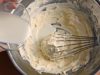 室温に戻しておいたクリームチーズとバターを泡立て器でなめらかになるまでよく混ぜ合わせる。牛乳を少しずつ加え、そのつどよく混ぜる。<br />