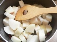 鍋にサラダ油を熱し、ニンニクを炒める。香りが出たらベーコンと赤唐辛子を入れて軽く炒め、大根も入れて炒める。<br />