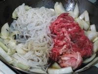 フライパンに油を入れて弱めの中火にかけ、玉ねぎを炒め、玉ねぎが柔らかくなったら牛肉、しらたき、醤油、日本酒、砂糖、みりんを入れて炒める。