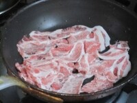 フッ素樹脂加工のフライパンに豚肉を広げて入れ、塩を加えて弱めの中火にかける。<br />