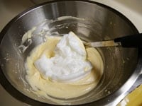 1のボウルにまずは、泡立てた生クリームを加え、泡だて器で混ぜ合わせます。次にメレンゲをへらを使って2～3回に分けて、さっくり切るように混ぜ合わせます。<br />
