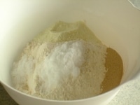 ボウルに強力粉、イースト、砂糖、塩、スキムミルクを入れざっくりと混ぜます。この時、塩とイーストは隣接しないように気をつけましょう。<br />