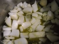 厚底鍋にオリーブオイルとニンニクを入れ、弱めの中火にかける。ニンニクの香りが出たら、一口大に切ったタマネギを入れて炒める。<br />
