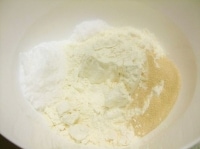 ボウルに強力粉、イースト、砂糖、塩を入れざっくりと混ぜます。この時、塩とイーストは隣接しないように気をつけましょう。<br />