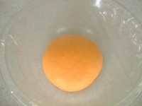 薄く油脂を塗ったボウルに生地を入れ、ラップをして一次発酵をします。35度で40分程度を目安に生地が2倍に膨らむまで発酵させます。<br />
<br />
