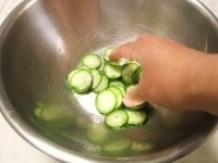 ボウルにきゅうりを入れ、塩を加えて手で軽くもみます。そのまま10分程置き、ぎゅっと絞ってきゅうりの水気を取っておきます。<br />