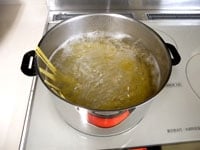 たっぷりの湯が沸騰したら、塩大さじ1を加えパスタを茹でます。茹で時間は、袋の表示時間よりも少し長く茹でます。茹で上がったら、冷水で洗い水気をしっかり切ります。<br />