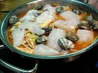 白身魚やアサリ、えのき茸、豆腐、ニラ、残りの白菜キムチも加え煮立ったら中火にします。