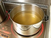 リゾットを白く仕上げたいので熱いチキンスープストックを作ります。市販のチキンスープを表示通りに溶かして使えば簡単にできます。
