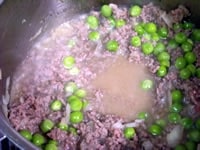 鍋にオリーブオイル、みじん切りのタマネギを入れ、中火にかけ、タマネギがしんなりしたらひき肉を入れ、塩をして炒め、グリーンピースを加え、白ワインを注ぎ入れる。