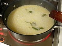 熱いチキンスープストック300ccを加えます。中火で混ぜながらはじめのひたひたのスープが、お米にしみ込んだらスープストックを少しずつ足して15分程煮ます。残りのシャンパンを加えて3分程煮て火を止めます。