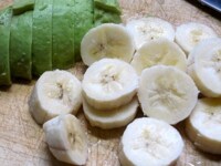 アボカドは半分に切って皮をむき、種をとって、5mm幅に切る。バナナは皮をむいてやはり5mm幅に切る。<br />