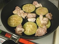 フライパンを熱し、ごま油を入れます。水気をふき取った茄子を中火で炒め、塩コショウを振った鶏肉を加えます。<br />