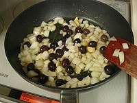 厚手のフライパンにオリーブ油とニンニクをいれ、中火にかけます。ニンニクの香りが立ってきたら、玉ねぎを炒め、ケイパー、黒オリーブも加え炒めます。<br />
&nbsp;
