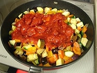 つぎにトマト缶とローリエを入れ、蓋をします。焦げ付かないように中火弱で２０分ほど煮込みます。塩で味をととのえます。