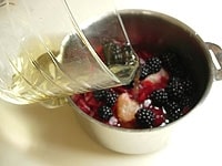 鍋にフルーツ、グラニュー糖、白ワインを加え中火にかけます。<br />