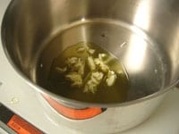 鍋にオリーブオイルとにんにくを入れ、中火弱で熱しにんにくを炒めます。<br />