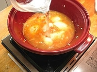 次にカレー粉を振り入れ、そっと混ぜ合わせ固形スープの素と水、ブーケガルニを入れて蓋をし、弱火で15分ほど煮込みます。<br />