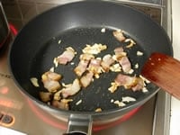 フライパンにオリーブオイルとにんにくを入れて火にかけ、ベーコンを加えて炒めます。<br />
<br />