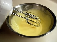 ボウルに卵黄を入れ、ハンドミキサーで軽く溶きほぐしてからグラニュー糖の半分（30g）を2回くらいに分けて加え、よく混ぜ合わせます。<br />