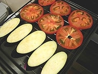 トマトは１cm厚の輪切りにします。両端は粗みじんぎりにします。なすは縦に１cm厚に切り、水にはなしアク抜きをして水気をふき取ります。グリルを高温にして焼きます。<br />