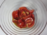 レンジ加熱の間に、ソースを作ります。<br />
トマトはくし切り（ざく切りや角切りでも）にし、塩、レモン汁、オリーブオイルと和えます。