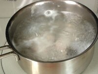 たっぷりの熱湯に塩小さじ1を加え、タラの切り身を2分ほど茹でます。ざるに取り冷ましてから、骨と皮、血合いなどを取り除きます。