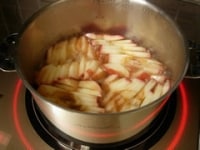 リンゴに透明感が出てきたら蓋を取り強火で少し焦すようにしてカラメリゼし火を止めます。ここで鍋のサイズに切った冷凍のパイシートをオーブンで焼いたのを、かぶせて返すとタルト・タタンになります。今回は4枚の丸型の食パンを使います。