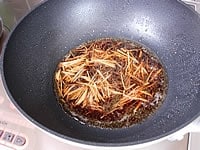 カツオを取り出したフライパンに生姜のせん切りと黒酢、醤油、酒を加えひと煮立ちさせタレをつくります。<br />