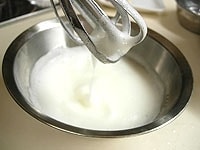 別にボウルを用意して、卵白に残り砂糖20gを少しずつ加え、しっかりあわ立てメレンゲを作ります。<br />