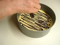 湯煎で溶かしたチョコレートを、スプーンを使って細く模様を描きます。<br />