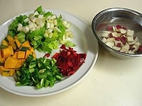 付け合せの野菜類（さつま芋、かぼちゃ、赤、緑ピーマン、セロリ）はそれぞれ1cm角くらいのさいの目に切ります。さつま芋は切ったら水に漬けておきます。<br />