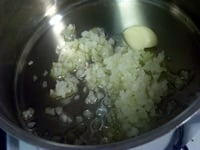 厚底鍋にタマネギのみじん切り、芯を取り除いたニンニク、オリーブオイル大さじ1を加え中火にかける。焦げないように気をつけながら、香りを出す。<br />