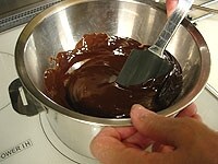 ボウルに刻んだチョコレートとバターをいれ、60度の湯せんにかけて滑らかに溶かします。