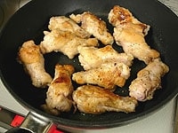 別のフライパンか鍋にオリーブオイル大さじ1を熱し、鶏肉の両面に焼き色をつけます。<br />